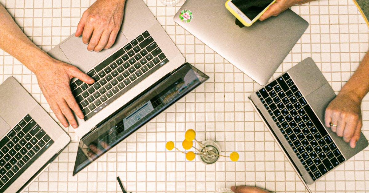Top view of a team collaborating with laptops, phones, and notes in a modern office.